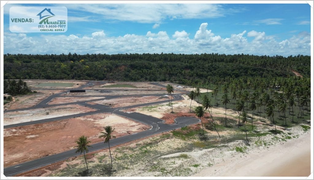 Vista aérea de um terreno em Coruripe, Alagoas, com áreas de construção, vegetação e céu azul com nuvens, ideal para imóveis à venda.