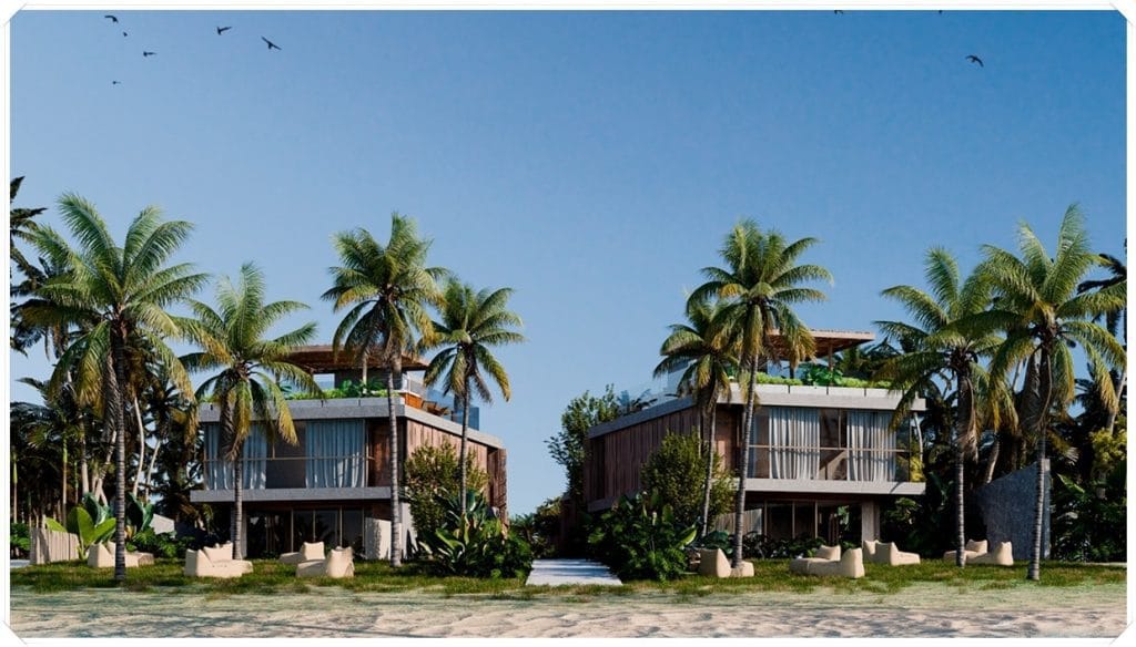 Dois edifícios modernos com janelas amplas, cercados por palmeiras e vegetação tropical, sob um céu claro e azul.