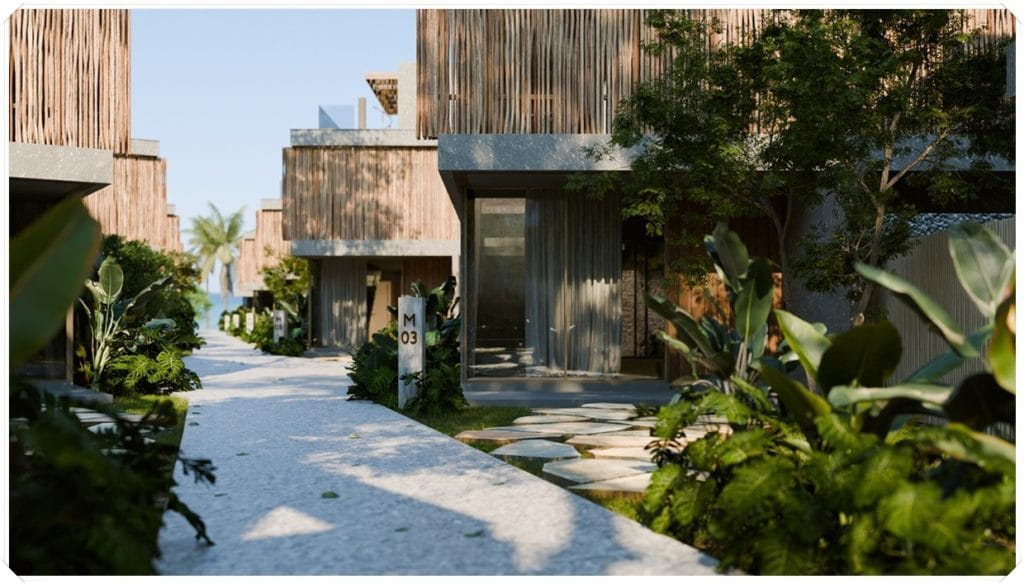 Caminho ajardinado entre casas modernas com fachadas de madeira, cercado por plantas exuberantes e iluminação natural.