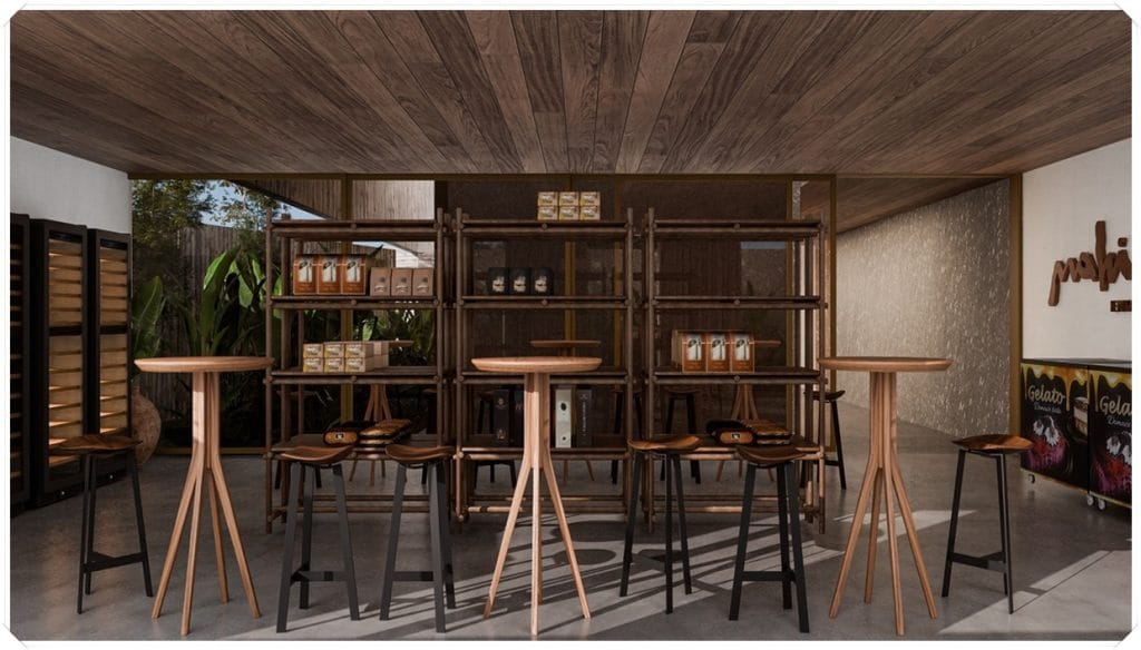 Ambiente interior com mesas altas em madeira, cadeiras, estante de produtos e iluminação natural, criando um espaço acolhedor.