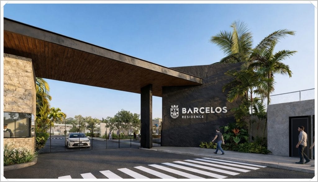 Entrada do Residencial Barcelos, com portão moderno, vegetação tropical e um carro estacionado, sob um céu azul claro.