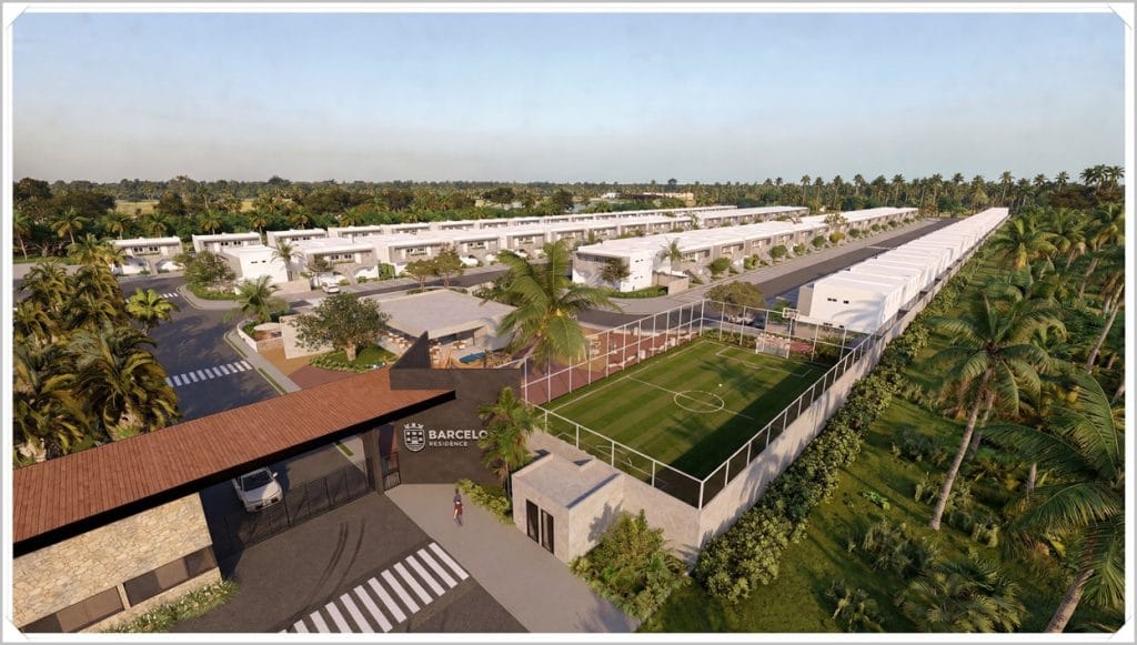 Vista aérea do Residencial Barcelos, mostrando casas, áreas verdes, campos esportivos e acesso principal entre palmeiras.